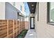 Modern home featuring a private side entrance with sleek design, black trim, and wooden fence at 1236 N Tennyson St, Denver, CO 80204
