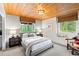 Cozy bedroom with wood plank ceiling, natural light, and tranquil views of the surrounding landscape at 592 Brook Dr, Idaho Springs, CO 80452