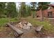 A cozy stone fire pit area with log benches, nestled among mature trees, offers a secluded spot for outdoor gatherings at 592 Brook Dr, Idaho Springs, CO 80452