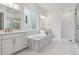 Bright bathroom with dual sinks, marble-trimmed tub, and large walk-in shower at 8607 Yellowcress St, Littleton, CO 80125