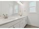 Modern bathroom with double sinks, large mirror, and white cabinetry at 8607 Yellowcress St, Littleton, CO 80125
