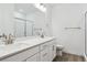 Bathroom boasts dual sinks, white cabinets, and a walk-in shower with glass doors at 8607 Yellowcress St, Littleton, CO 80125