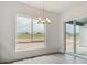 Bright dining area features sliding glass doors, chandelier and a large window overlooking the backyard at 8607 Yellowcress St, Littleton, CO 80125