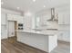 Bright kitchen features white cabinets, stainless steel hood, and large island with countertop seating at 8607 Yellowcress St, Littleton, CO 80125