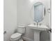 Contemporary powder room with pedestal sink and oval mirror at 8607 Yellowcress St, Littleton, CO 80125