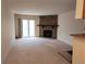 Open living room with a stone fireplace and sliding door to a private balcony at 8335 Fairmount Dr # 8-206, Denver, CO 80247