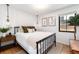 Cozy bedroom features a black metal bed frame, wood floors, and ample natural light from the window at 1065 S Monroe St, Denver, CO 80209
