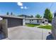 Exterior shot of a white house featuring a backyard patio and detached garage at 1065 S Monroe St, Denver, CO 80209