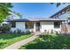 Charming painted brick home with well-manicured lawn and walkway at 1065 S Monroe St, Denver, CO 80209