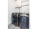 Functional laundry room with modern washer and dryer, stylish patterned floors, and storage at 1065 S Monroe St, Denver, CO 80209