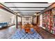 Inviting dining room with wooden beams, decorative rug, library, and comfortable seating area at 555 E 10Th Ave # 111, Denver, CO 80203