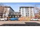 Apartment building featuring multiple windows, balconies, and street parking on a sunny day at 555 E 10Th Ave # 111, Denver, CO 80203