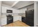 Bright kitchen with white cabinets, black appliances, and a charming tile backsplash at 555 E 10Th Ave # 111, Denver, CO 80203