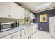 Efficient kitchen featuring white cabinetry, a microwave, a stove, and a convenient layout for cooking at 555 E 10Th Ave # 111, Denver, CO 80203