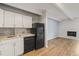 Efficient kitchen featuring white cabinets, and modern appliances adjoining a bright living space at 555 E 10Th Ave # 111, Denver, CO 80203