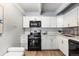 Stylish kitchen with white cabinetry, black appliances, and wood-look flooring at 555 E 10Th Ave # 111, Denver, CO 80203