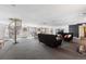 Open concept living space with spiral staircase, dark sofas, dining table, and large windows for natural light at 555 E 10Th Ave # 111, Denver, CO 80203