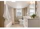 Charming bathroom featuring a tiled shower/tub, decorative window, and a vanity with ample storage space at 377 Stuart St, Denver, CO 80219