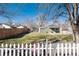 Charming single-story home boasts a well-maintained front lawn, framed by a classic white picket fence and mature trees at 377 Stuart St, Denver, CO 80219