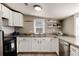 Well-lit kitchen with white cabinets, granite countertops, and modern stainless steel appliances at 377 Stuart St, Denver, CO 80219