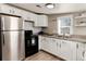 Well-lit kitchen featuring stainless steel appliances, granite countertops, and white cabinets at 377 Stuart St, Denver, CO 80219
