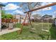 This beautiful backyard includes a wooden swing set, patio seating, and plenty of lawn space at 2896 Depew St, Wheat Ridge, CO 80214