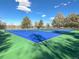 Two tone tennis courts with surrounding trees and lake in background, perfect for outdoor recreation at 2896 Depew St, Wheat Ridge, CO 80214
