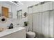 Cozy bathroom with a modern vanity, decorative mirror, and elegant shower curtain at 9301 Ciancio St, Thornton, CO 80229