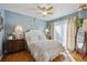 Comfortable bedroom with hardwood floors, blue walls, and a sliding glass door at 9301 Ciancio St, Thornton, CO 80229