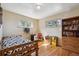 Guest bedroom with hardwood floors, a bookshelf, and two windows at 9301 Ciancio St, Thornton, CO 80229