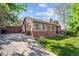 Quaint brick home featuring an American flag, garden, outdoor seating, and a private entrance at 9301 Ciancio St, Thornton, CO 80229
