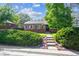 Brick home with a well-kept lawn, mature trees, a sidewalk entry, and landscaped bushes at 9301 Ciancio St, Thornton, CO 80229