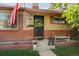 Charming entryway features a decorative door, bench seating, potted plants, and American flag at 9301 Ciancio St, Thornton, CO 80229