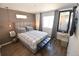 Bedroom with sleek floors, large mirror, and a window with curtains at 17747 E 54Th Ave, Denver, CO 80249