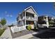 Charming two-story home featuring a balcony, gray siding, white picket fence, and rock landscaping at 17747 E 54Th Ave, Denver, CO 80249