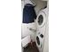 Convenient laundry closet with a stacked washer and dryer unit and clothing rack at 17747 E 54Th Ave, Denver, CO 80249