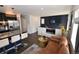 Open-concept living area with a modern fireplace, wall-mounted TV, and stylish decor, perfect for relaxing and entertaining at 17747 E 54Th Ave, Denver, CO 80249
