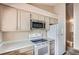 Bright kitchen features stainless steel microwave, white refrigerator and range, and light countertops at 4135 E 119Th Pl # A, Thornton, CO 80233