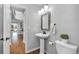 Small bathroom with pedestal sink, toilet, and framed mirror at 22196 Boar Head Rd, Indian Hills, CO 80454