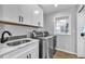 Laundry room with white cabinets, quartz countertops, and a utility sink at 22196 Boar Head Rd, Indian Hills, CO 80454