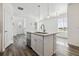 Kitchen island with a sink and dishwasher with wood-look flooring at 458 Millwall Cir, Castle Pines, CO 80108