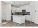 Modern kitchen with stainless steel appliances, a center island, and grey tile backsplash at 458 Millwall Cir, Castle Pines, CO 80108