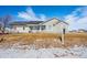 Charming single-story home with a well-manicured lawn and classic architectural details, set against a clear blue sky at 51 W 6Th Pl, Byers, CO 80103