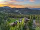 Elevated view of a sprawling home surrounded by trees with a view of the valley at 34089 Woodland Dr, Evergreen, CO 80439