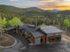 Scenic aerial view of home at dusk with a long driveway and an attached garage at 34089 Woodland Dr, Evergreen, CO 80439
