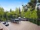 Outdoor dining area on a spacious deck, featuring a built-in grill and forested views at 34089 Woodland Dr, Evergreen, CO 80439