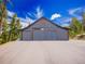 Charming barn featuring three garage doors at 34089 Woodland Dr, Evergreen, CO 80439