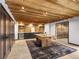 Spacious basement featuring a wood ceiling, unique game table, kitchenette, and glass-enclosed room at 34089 Woodland Dr, Evergreen, CO 80439