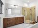Sleek bathroom featuring a wood vanity, white tile backsplash, and glass shower enclosure at 34089 Woodland Dr, Evergreen, CO 80439