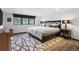 Serene bedroom with plush rug, large window overlooking trees, and dark wood accents at 34089 Woodland Dr, Evergreen, CO 80439